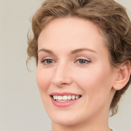 Joyful white young-adult female with medium  brown hair and green eyes