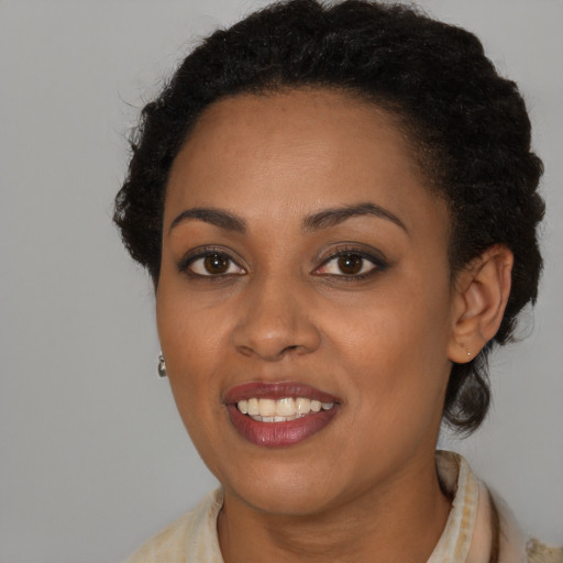 Joyful black young-adult female with short  brown hair and brown eyes