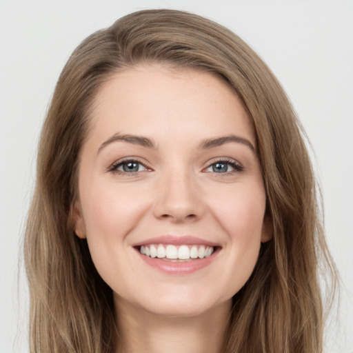 Joyful white young-adult female with long  brown hair and grey eyes