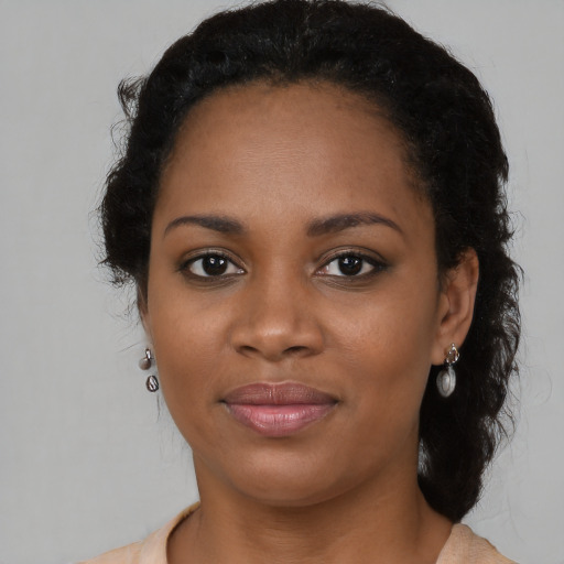 Joyful black young-adult female with long  brown hair and brown eyes