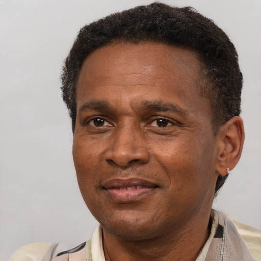 Joyful black adult male with short  brown hair and brown eyes