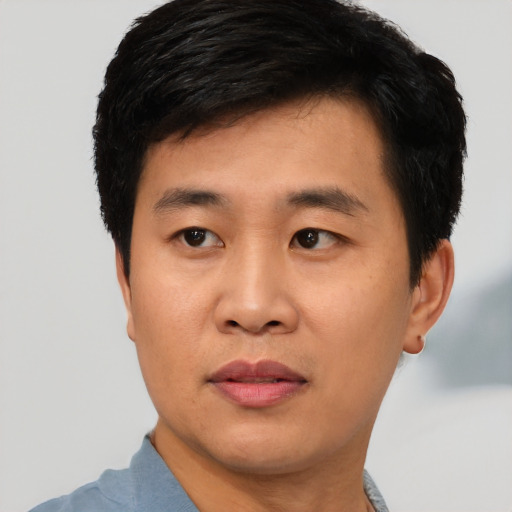 Joyful asian young-adult male with short  black hair and brown eyes