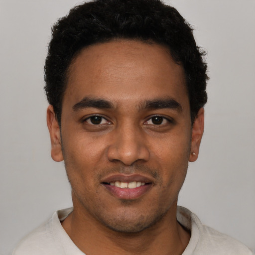 Joyful black young-adult male with short  black hair and brown eyes