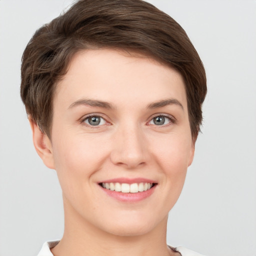 Joyful white young-adult female with short  brown hair and grey eyes