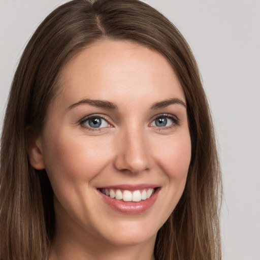 Joyful white young-adult female with long  brown hair and grey eyes