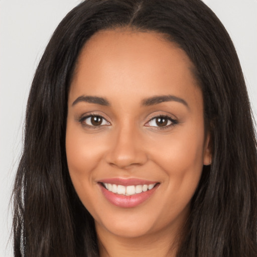 Joyful latino young-adult female with long  brown hair and brown eyes