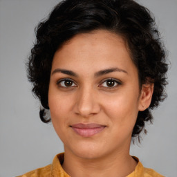 Joyful latino young-adult female with medium  brown hair and brown eyes