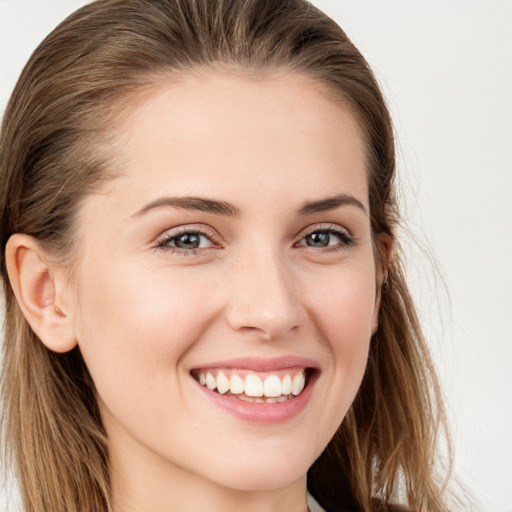 Joyful white young-adult female with long  brown hair and grey eyes