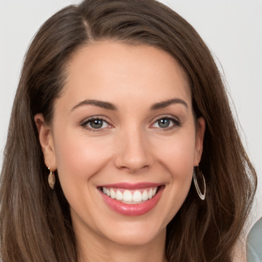 Joyful white young-adult female with long  brown hair and brown eyes