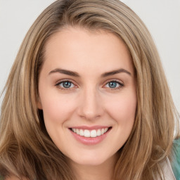 Joyful white young-adult female with long  brown hair and green eyes