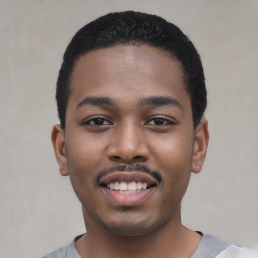 Joyful black young-adult male with short  black hair and brown eyes