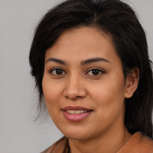 Joyful latino young-adult female with medium  brown hair and brown eyes