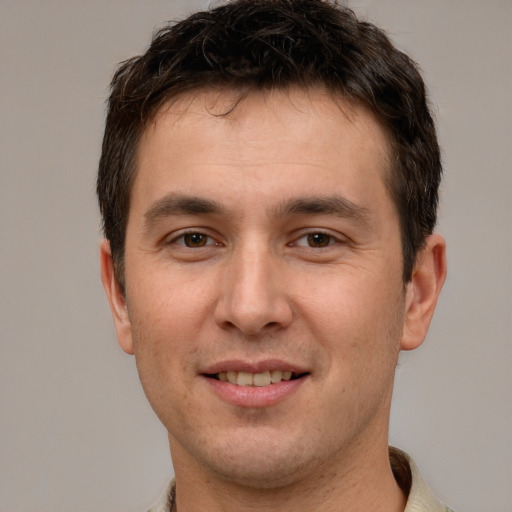 Joyful white young-adult male with short  brown hair and brown eyes