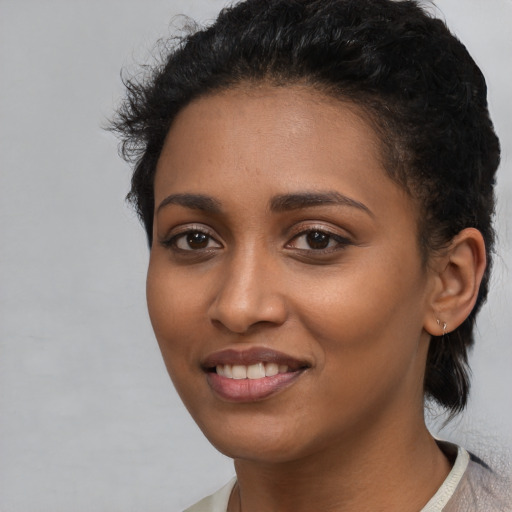 Joyful latino young-adult female with short  black hair and brown eyes