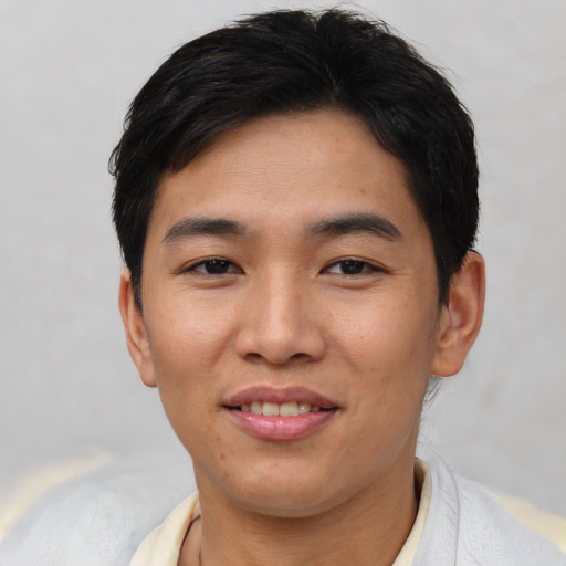 Joyful asian young-adult male with short  black hair and brown eyes