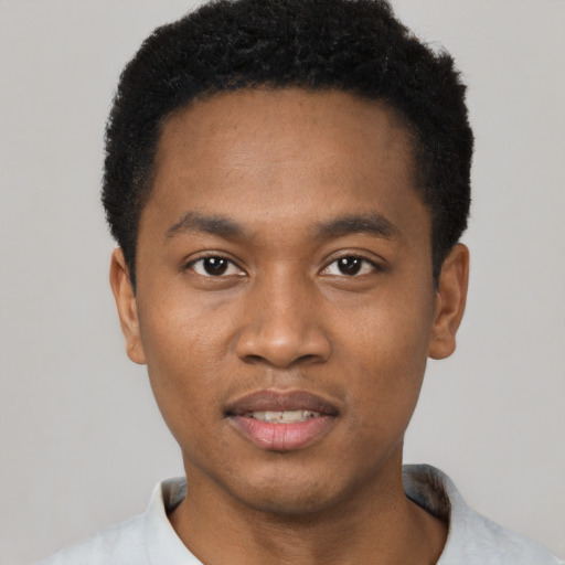 Joyful black young-adult male with short  black hair and brown eyes