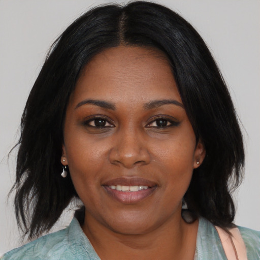 Joyful black young-adult female with medium  black hair and brown eyes