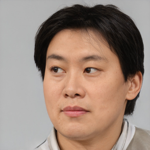 Joyful asian adult male with medium  brown hair and brown eyes