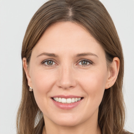 Joyful white young-adult female with long  brown hair and brown eyes