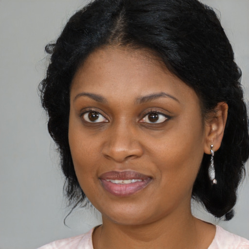 Joyful black young-adult female with medium  black hair and brown eyes