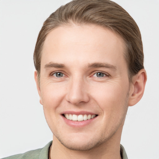 Joyful white young-adult male with short  brown hair and grey eyes