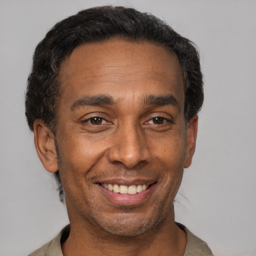 Joyful black adult male with short  brown hair and brown eyes