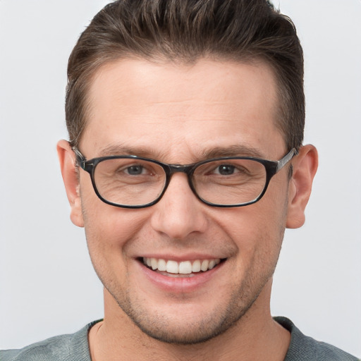 Joyful white young-adult male with short  brown hair and grey eyes