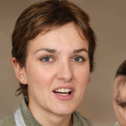 Joyful white young-adult female with medium  brown hair and grey eyes