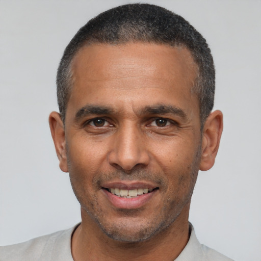 Joyful latino adult male with short  black hair and brown eyes
