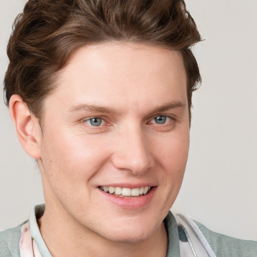 Joyful white young-adult male with short  brown hair and blue eyes