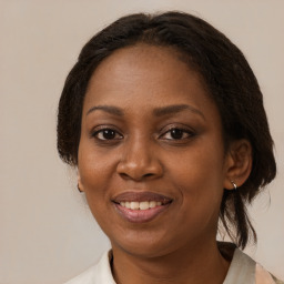 Joyful black adult female with medium  brown hair and brown eyes