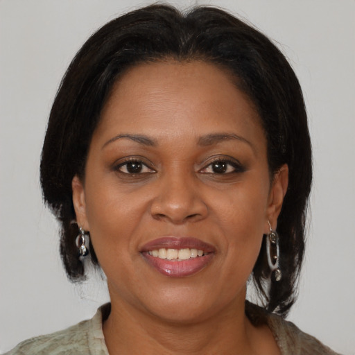 Joyful black adult female with medium  brown hair and brown eyes