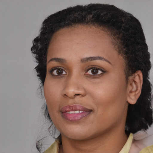Joyful black young-adult female with medium  black hair and brown eyes