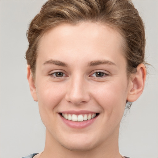 Joyful white young-adult female with short  brown hair and grey eyes