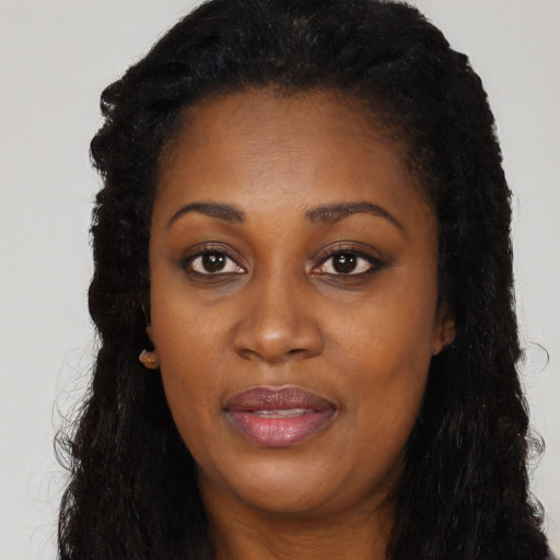 Joyful black young-adult female with long  black hair and brown eyes