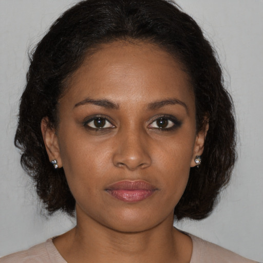Joyful black young-adult female with medium  brown hair and brown eyes