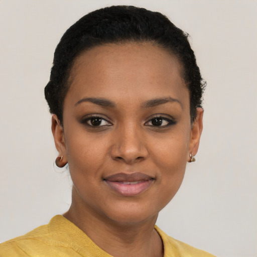 Joyful black young-adult female with short  black hair and brown eyes
