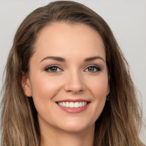 Joyful white young-adult female with long  brown hair and grey eyes