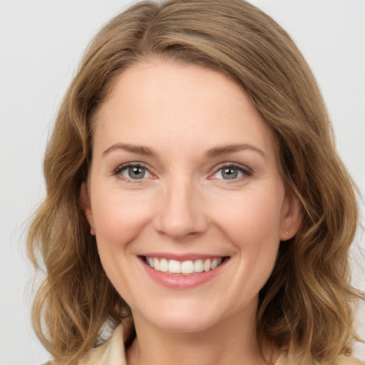 Joyful white young-adult female with medium  brown hair and green eyes