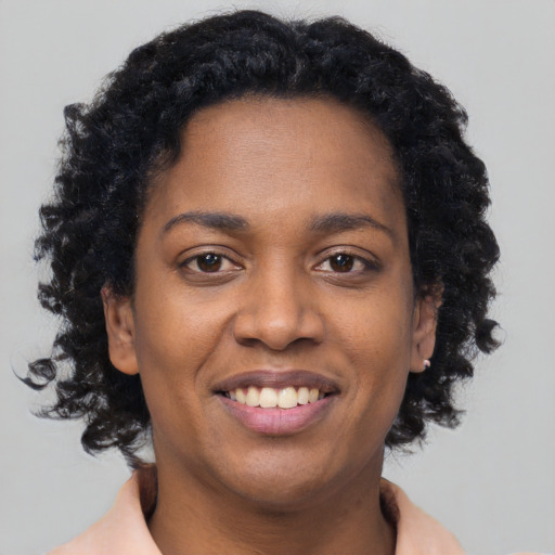 Joyful black young-adult female with short  brown hair and brown eyes