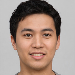 Joyful asian young-adult male with short  brown hair and brown eyes