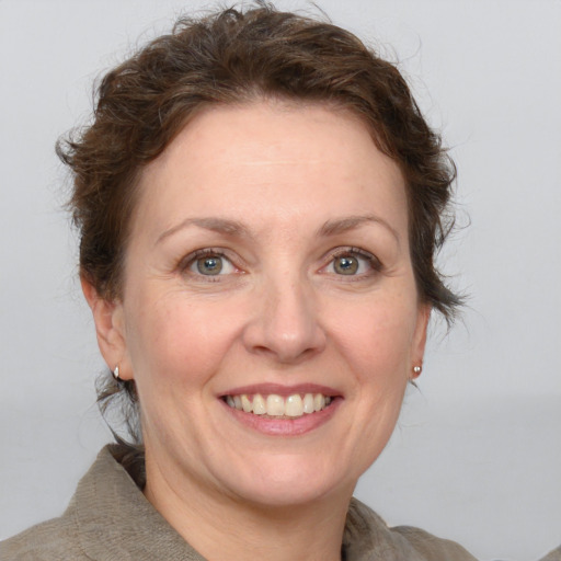 Joyful white adult female with medium  brown hair and grey eyes