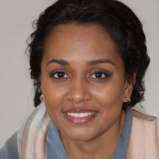 Joyful black young-adult female with medium  brown hair and brown eyes