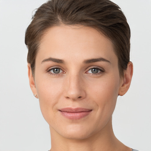 Joyful white young-adult female with short  brown hair and grey eyes