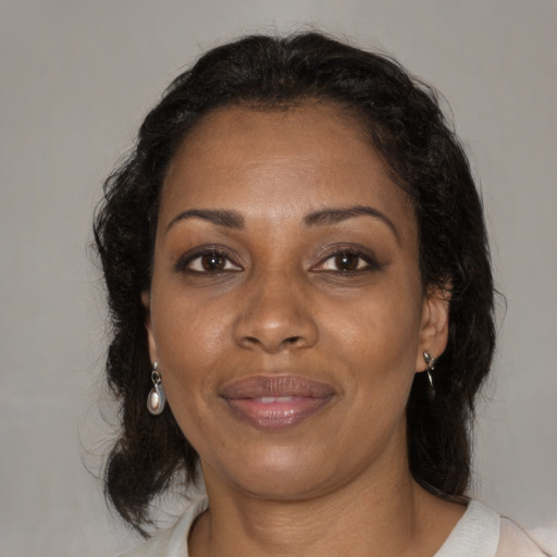 Joyful black adult female with medium  brown hair and brown eyes