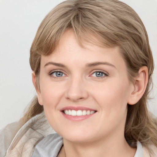 Joyful white young-adult female with medium  brown hair and blue eyes