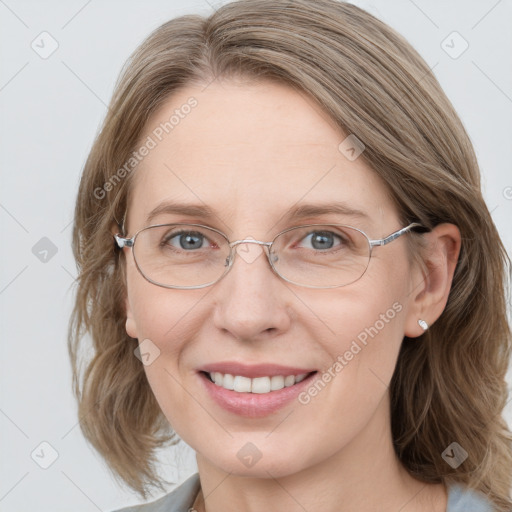 Joyful white adult female with medium  brown hair and blue eyes