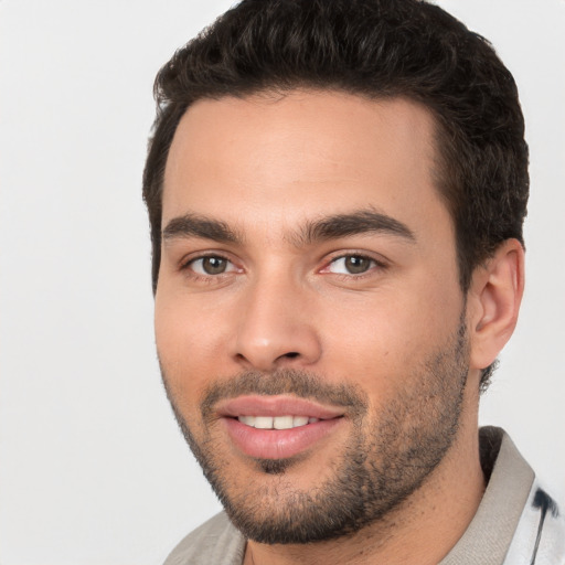 Joyful white young-adult male with short  black hair and brown eyes