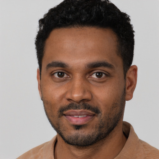 Joyful black young-adult male with short  black hair and brown eyes