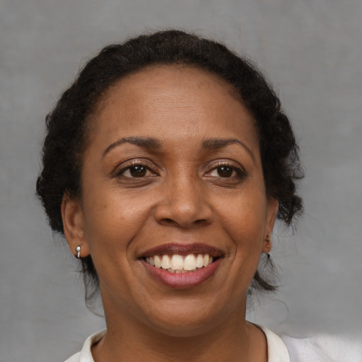 Joyful black adult female with short  brown hair and brown eyes
